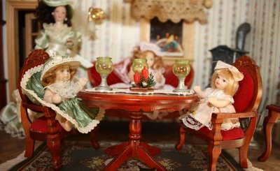 Puppen sitzen am Tisch im gemütlichen Wohnzimmer. 
