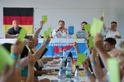 Leipzigs AfD-Kreisvorsitzender Siegbert Droese spricht in Dohna zu den Parteimitgliedern, die ihre grünen Stimmkarten hochhalten.