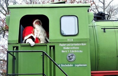 Der Weihnachtsmann fährt mit der Lok im Museum vor. 
