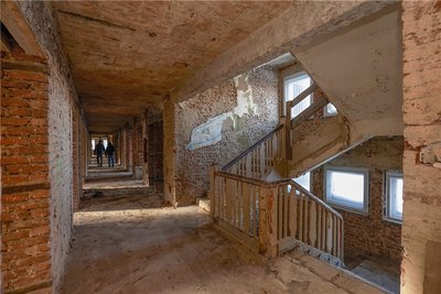 Blick ins Treppenhaus und in einen der langen Flure des Altbaus. Auch hier ist schon alles beräumt. 