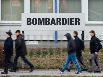             Mitarbeiter gehen am Werk von Bombardier vorbei.