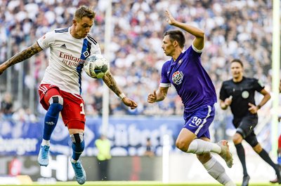 Hamburgs Sonny Kittel (l) nimmt den Ball vor Sören Gonther von Aue an.