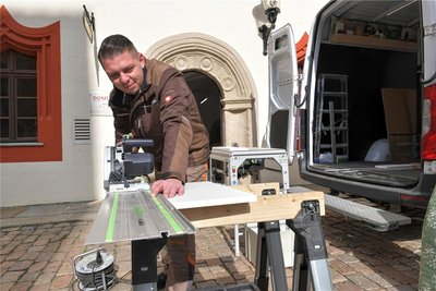 David Groß von der Firma Premium Möbel Erzgebirge sägt die letzten Bestandteile der neuen Einrichtung für den Domladen in Freiberg zurecht.