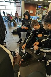 Sinnbild für eine besondere Mannschaft: National- und Jugendspieler beim gemeinsamen Kartenspielen am Flughafen. Hier spielen unter anderen Kaza Kajami Keane (rechts) und Luca Kellig.