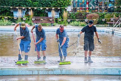 Am Tag nach der Flut sind freiwillige Helfer aus Chemnitz dabei, die Schlammmassen aus dem Burkhardtsdorfer Bad zu entfernen.