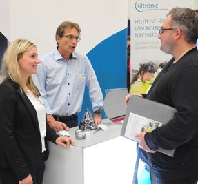 Am Stand von Siltronic befragt Maik Gerwig (r.) die Mitarbeiter Christin Disnovski und Rüdiger Zschoke.
