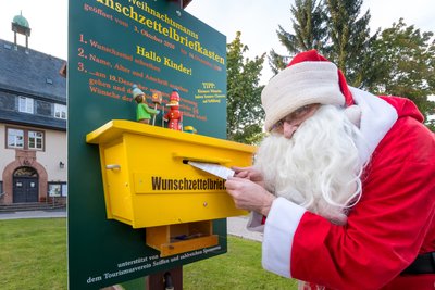 Der Weihnachtsmann, verkörpert von Axel Wiedemann, hat seinen Wunschzettelbriefkasten wieder vor dem Seiffner Rathaus angebracht.