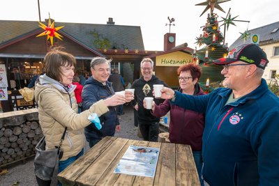 Gäste aus Altenburg, mit denen Vor-Adventsmarkt Initiator Tino Günther (Mitte) ins Gespräch kam, stießen kurz nach der Eröffnung des Marktes mit einer "Heißen Olga" an.