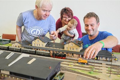 Benny Michalke (rechts) mit Jürgen Frischmann an der Anlage "Bahnhof Limbach". Sein Sohn Bruno (hier mit seiner Mutter Beatrix) verfolgt das Geschehen bereits interessiert. 