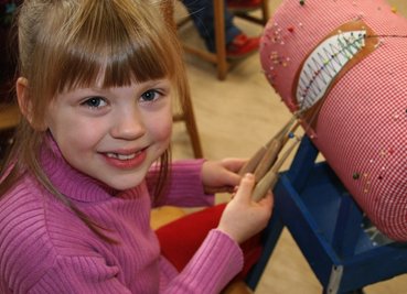 
              <p class="artikelinhalt">Rein, raus, kreuzen und straff ziehen: Bianca Päßler hat in Pöhla einen ersten Grundschlag gelernt. Damit kann die Siebenjährige zum Beispiel schon eine Sonne als Motiv klöppeln. </p>
            