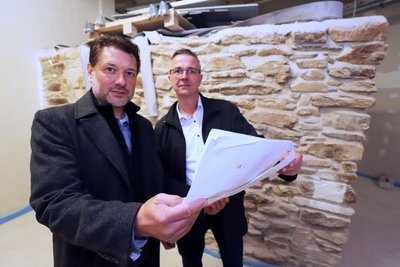 RWR-Objektbetreuer Steffen Uhlmann (l.) und AWO-Geschäftsführer Jörg Lehmann bei den historischen Mauern im Erdgeschoss des neuen Service-Wohnens am Dom in Freiberg.