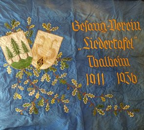 Das Symbol der drei Tannen auf einer historischen Vereinsfahne. Es ist nicht der einzige Platz, wo das Signet in Thalheim präsent ist. 