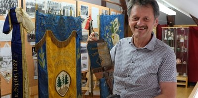 Uwe Lindner ist neuer Vorsitzender des Heimatkundlichen Vereins Thalheim. Er freut sich über diesen Stammtisch-Wimpel des Gesangsvereins Liederkranz, der dem Verein vor wenigen Tagen als Schenkung aus Privathand überlassen wurde. Mit dem Drei-Tannen-Symbol im Sockel passt das Exponat bestens in die neue Ausstellung des Vereins.