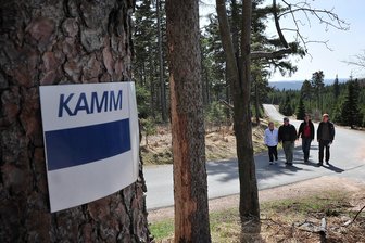 15 Jahre Kammweg Erzgebirge-Vogtland: Eine Erfolgsgeschichte mit wachsenden Problemen - Grauer Balken auf weißem Grund, darüber blau das Wort „Kamm“: Wer dieser Markierung folgt, kommt auf knapp 290 Kilometern vom Osterzgebirge bis nach Thüringen.