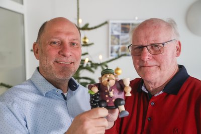 Geschäftsführer Erik Schindler (l.) überreicht dem ehemaligen Mitarbeiter Gunter Schlegel ein originales erzgebirgisches Räuchermännchen.