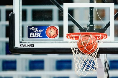 Eine Basketball landet im Netz.