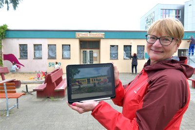 Jana Pinka von „Freiberg für alle“ zeigt, wie die Hausfront der Tafel aussehen soll.