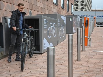 Entwickler Steve Winter demonstriert die Nutzung der neuen Fahrradgaragen am Carlowitz-Congresscenter. 