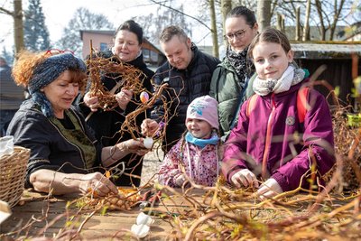 Fürs Kränzebinden mit Margitta Schier (l.) Interessieren sich Yvonne Rudolph, René Kakerbeck mit Emilia (4) aus Plauen sowie Sandy und Sara Hoffmann (rechts) aus Reichenbach.