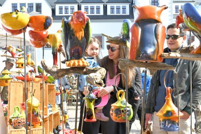 Anne und Markus Stammnitz aus Freiberg zeigen Töchterchen Nora die Figuren von Lilla Haz aus Ungarn.