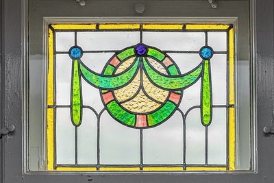 Verspielte Ornamente in Glasfenstern, ebenso in Türen und auf Kacheln verkörpern den Jugendstil.