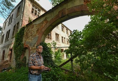 Bauamtschef Hannes Langen steht vor dem Torbogen des Gutes, der unter Denkmalschutz steht. 
