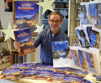 Thomas Augsten zeigt den Meerane-Kalender. Auf der Titelseite ist ein Blick auf den Teichplatz zu sehen. 