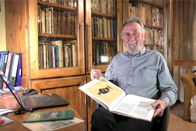 Knut Neumann am Schreibtisch in seinem Arbeitszimmer. Der Bücherschrank birgt auch zahlreiche Veröffentlichungen aus der Feder des Freibergers. Andere sind durch seine Mitwirkung entstanden.