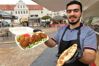 Mohammad Al- Oulabi aus Syrien kocht zusammen mit seinen Eltern zum Streetfood-Festival syrische Spezialitäten, darunter Falafel-Sandwiches und Shawanna-Sandwiches. Die Al-Oulabis sind in der Stadt gut bekannt als ständige Händler auf dem Freiberger Wochenmarkt.