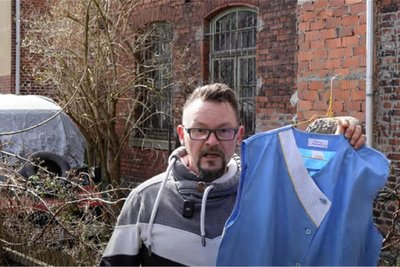 „Dor Micha“ aus Ellefeld vor Ziegelbaracke mit Kittelschürze im Spaß-Video zu "Mandat für Mai".