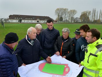 Nach dem ersten Spatenstich haben sich am Donnerstag die Vertreter der Verwaltung und Sportler den Bauplan für das neue Sportforum an der Pflaumenallee in Hainichen angeschaut.