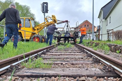 Mit schwerem Gerät wurde die Draisine in Neuhausen im Erzgebirge auf die Schiene gehievt.