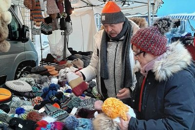 Johannes Steidl ist im Gespräch mit einer Kundin, um Mützen zu verkaufen. Er hat dieses Jahr vier Weihnachtsmärkte auf der Liste. 