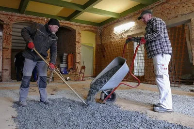 Im Eingangsbereich der Grundschule füllten Arbeiter in dieser Woche Kies auf, um eine Ausgleichsschicht zum vorhandenen Fußboden zu schaffen. Darauf kommen Planen, Leisten und Betonstahlmatten. 