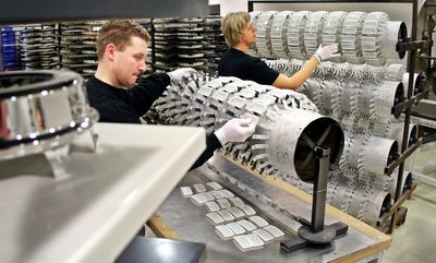 
              <p class="artikelinhalt">Maik Hupfer (l.) und Rommi von Ryssel bestücken Geräteträger mit Teilen vor der Oberflächenveredlung. Die Teile werden - so wie links im Vordergrund ein fertiges Stück - im Vakuum beschichtet, in dem eine völlig saubere Atmosphäre herrscht.</p>
            