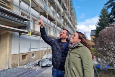 Wohnbau-Geschäftsführerin Julia Eichmann und Mitarbeiter Christian Günther an den Wohnblöcken Lindenstraße. 2026 stehen noch Arbeiten in den Treppenhäusern an.