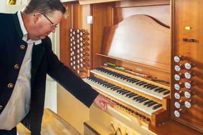 Mit Schaltern unter der Tastatur, die Kantor Schubert hier zeigt, lässt sich die programmierte Registrierung während des Spiels abrufen.