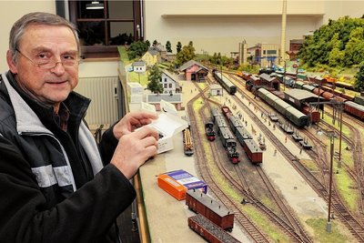 Reinhardt Pester vom Schwarzenberger Modelleisenbahn-Club bei letzten Vorbereitungen an der H-0-Clubanlage "Bahnhof Grünstädtel". Sie spiegelt den dortigen Betrieb in der Zeit etwa Mitte der 1960er-Jahre wider.