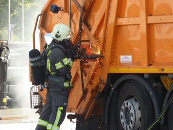 Um ans Innere der Müllpresse zu gelangen, musste eine Öffnung in den Stahl geschnitten werden. Scharniere wurden aufgeflext.