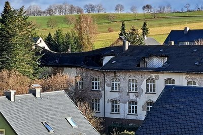Selbst aus großer Entfernung ist erkennbar, wie sehr der Zahn der Zeit vor allem am Dach genagt hat.