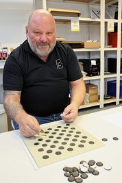 Mitarbeiter René Postler klebt die Indikatoren auf. 
