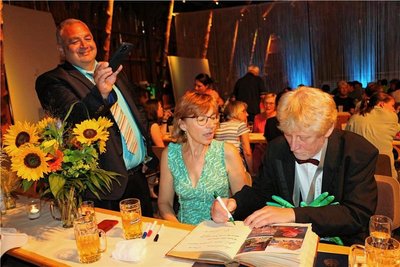 Henry Schneider – neben im Ehefrau Sabine - schreibt sich ins Ehrenbuch der Stadt Tanna ein. Bürgermeister Marco Seidel (links) hatte es mitgebracht.