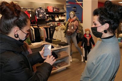 In einem Modegeschäft im Ring-Center Schwarzenberg kontrolliert Mitarbeiterin Katja Rockstroh (r.) am Eingang den digitalen Impfnachweis einer Kundin. 2G wird akzeptiert, macht Einkaufen aber schwieriger. 