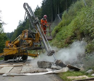 Mit einer Bohrlafette wird der mehr als zwei Tonnen schwere Felsbrocken aufgebrochen und in kleine Teile zerlegt. 