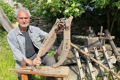 Andreas Schmidt bereitet eine kleine Ausstellung vor – mit Beispielen, wie im Dorf Landwirtschaft betrieben wurde, als die Sense noch eine Hauptrolle spielte, als Eggen und Pflüge noch von Pferden gezogen wurden. Hier hält er ein Kummet, Teil eines Zuggeschirrs.