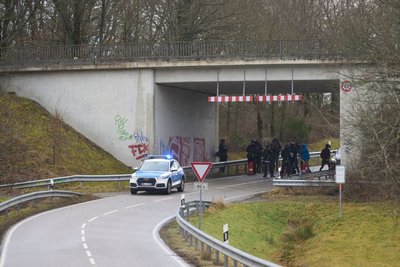 Polizisten sammeln sich an einer Unterführung.