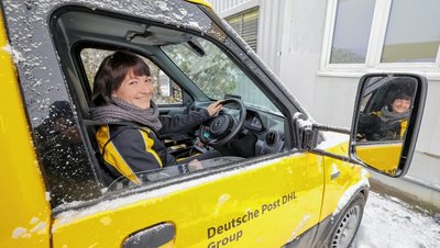 Die Glauchauer Standortleiterin Stefanie Bohnig auf dem Fahrersitz des ersten Rechtslenker-Elektro-Paketzustellerfahrzeugs der Deutschen Post im Landkreis Zwickau. 
