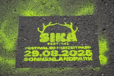 Studenten der Hochschule Mittweida werben mit diesem Logo (hier auf dem Gehweg) für das Sika-Festival im Sonnenlandpark.