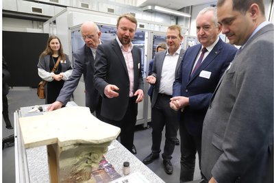 Wertstoffe aus Reststoffen: Henning Zeidler (3. v. l.) zeigt den Besuchern, was mit Hilfe des 3D-Druckers an der Bergakademie Freiberg entstehen kann.
