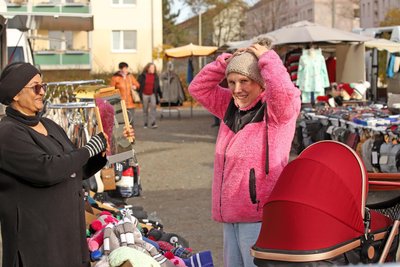 Jenny Burmeister probiert auf dem Wochenmarkt am Stand von Deepika Deol eine Mütze an. Der Markt erhält eine neue Fläche gleich nebenan.